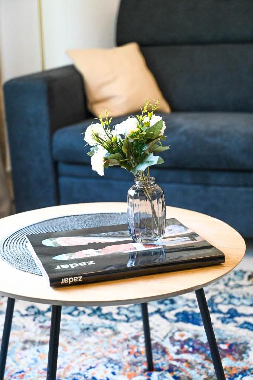 A Zadar guidebook and a vase of flowers on the round coffee table in the apartment